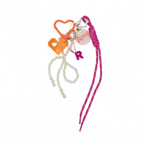 Raershop Pixel my Heart acrylic charm with orange heart, pearl beads, and pink rope on a white background